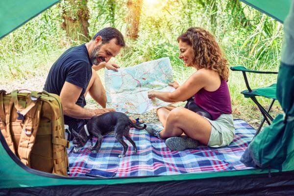 tipos de tienda de campaña pareja con perro mirando mapa